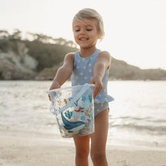 Child holding the Little Dutch Beach Bucket Ocean Dreams Blue at the beach