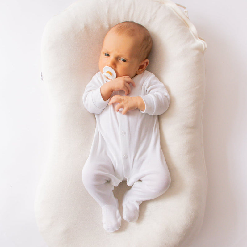 Baby lying in the Ko-Coon milky white nesting pod